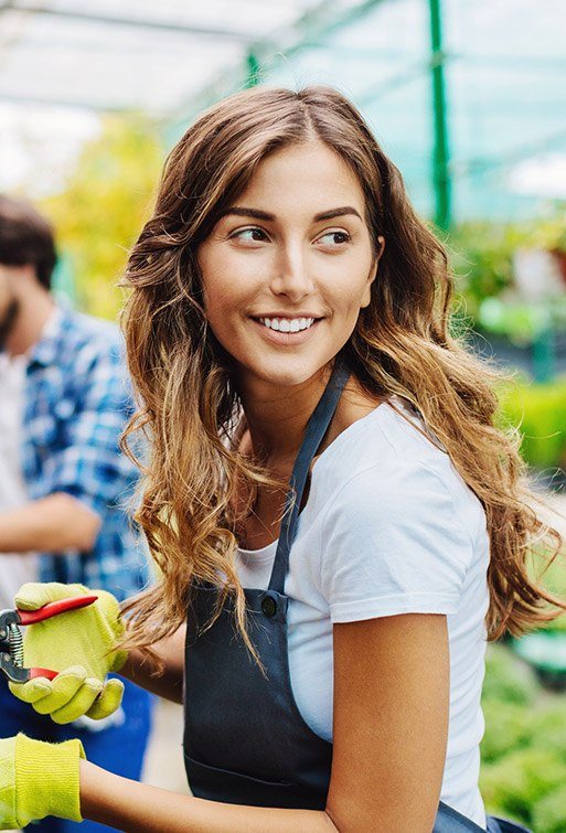 Woman displaying flawless smile while gardening