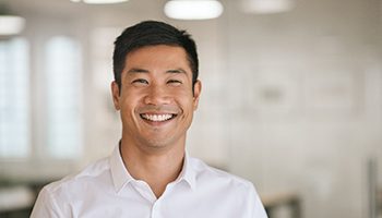 Man in white shirt smiling in office space