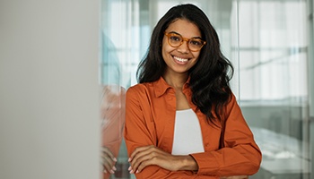 a smiling woman resting against a wall